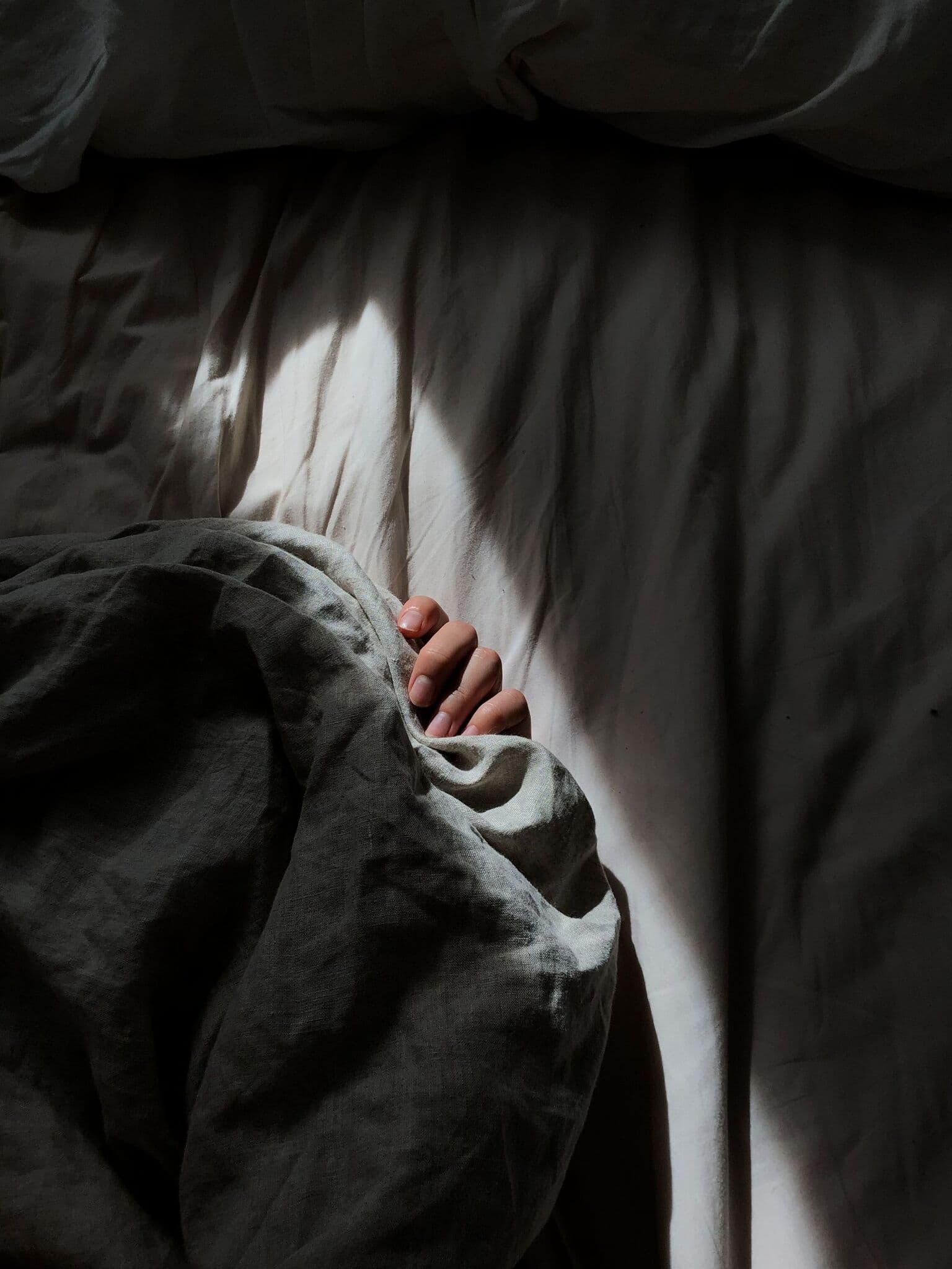 Person covered with gray blanket