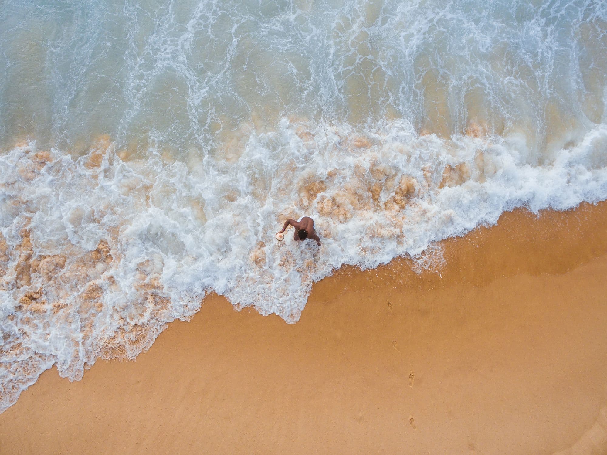 Overhead view of person walking on shore