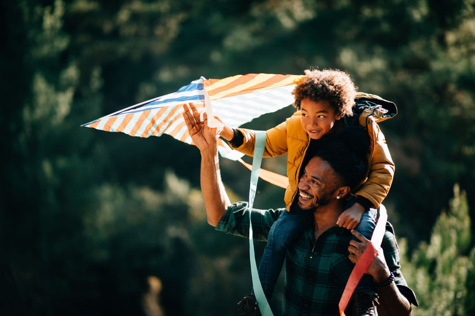 Father walking in nature with son on his shoulders