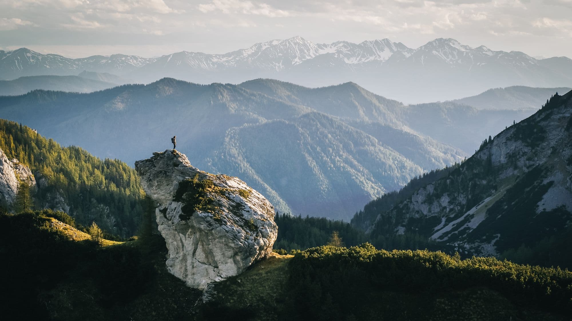 Hiker relaxes on mountain ridge at sunrise